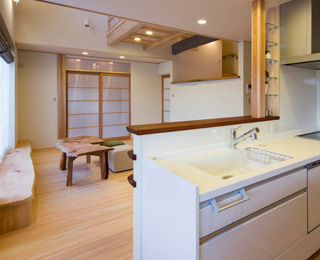 自然素材を使用した室内にオフホワイトのキッチンを採用した落ち着きあるデザイン